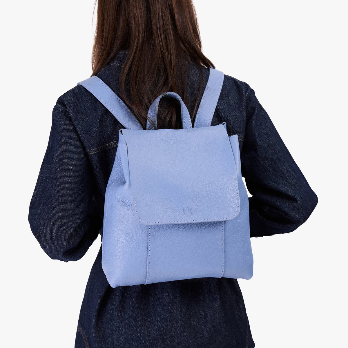 Aster | Model wearing a leather backpack on a white background