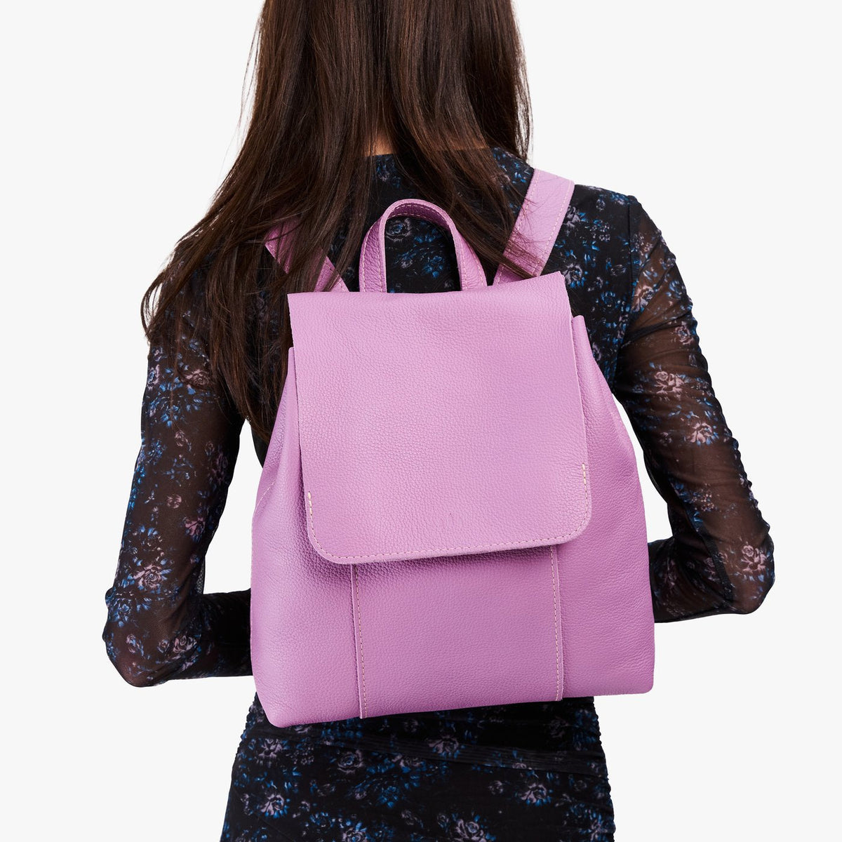 Calla Lily | Model wearing a leather backpack on a white background