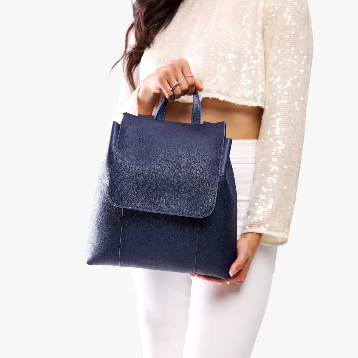 Cobalt | Model wearing a leather backpack on a white background