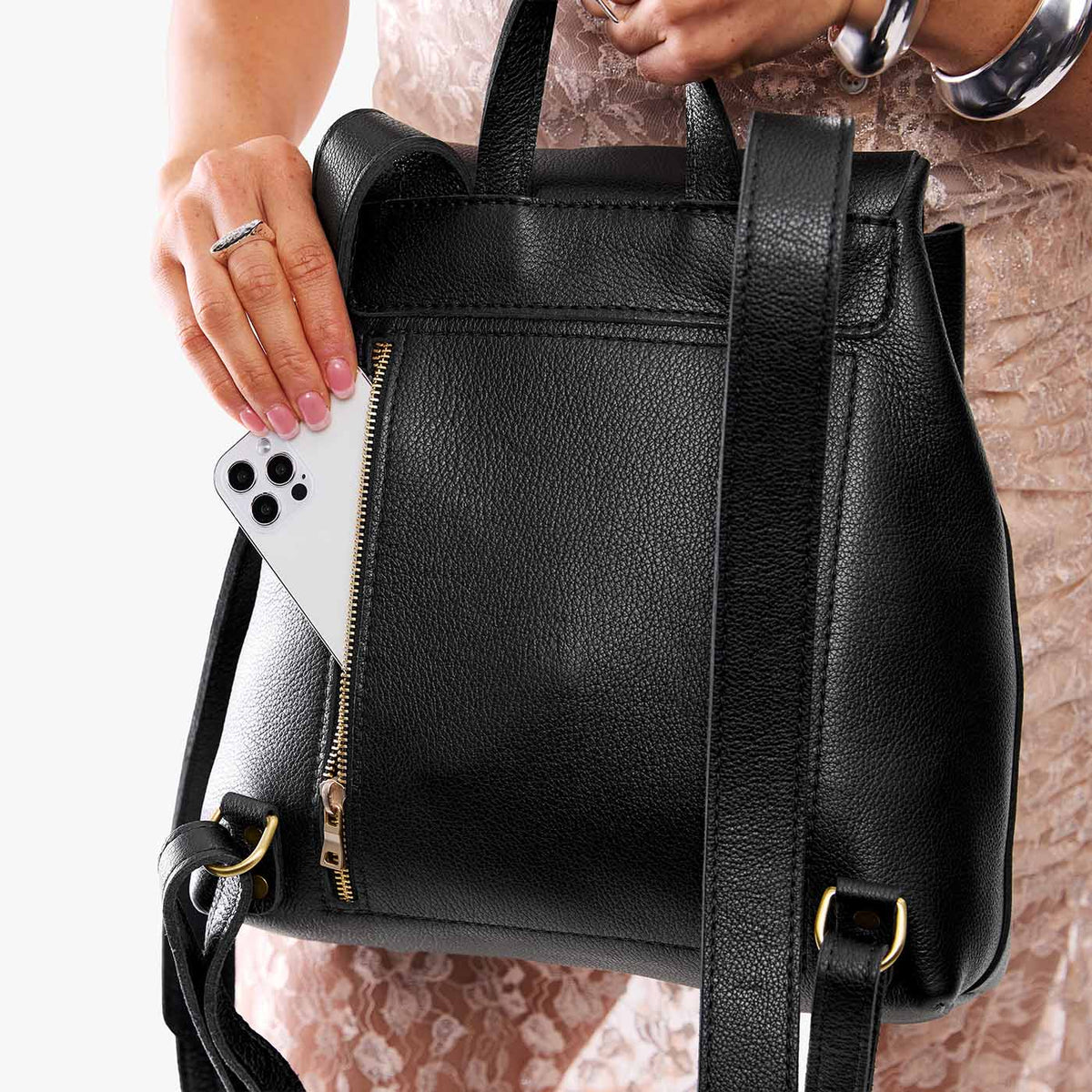 Pebbled--black | Model wearing a leather backpack on a white background