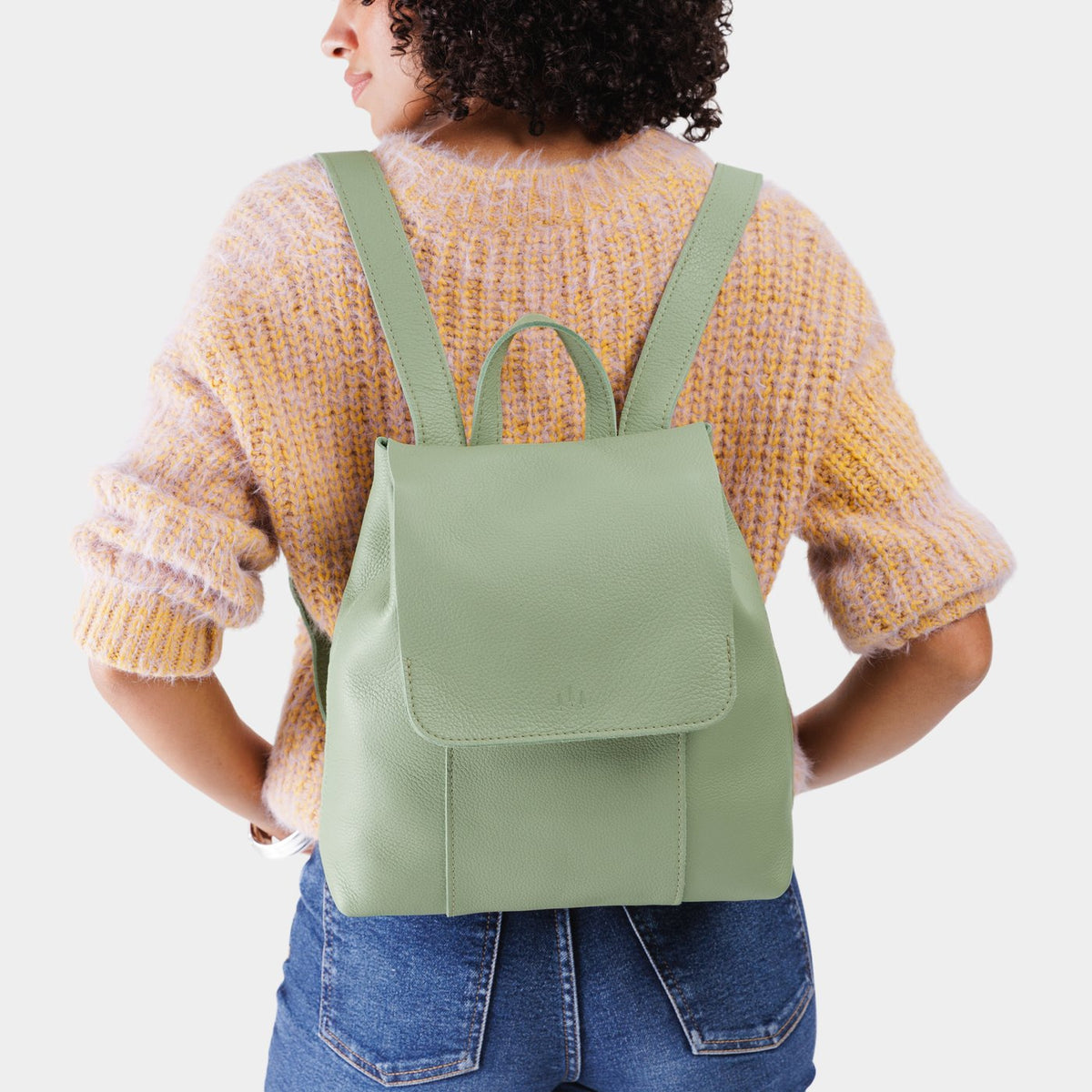 Pistachio | Model wearing a leather backpack on a white background