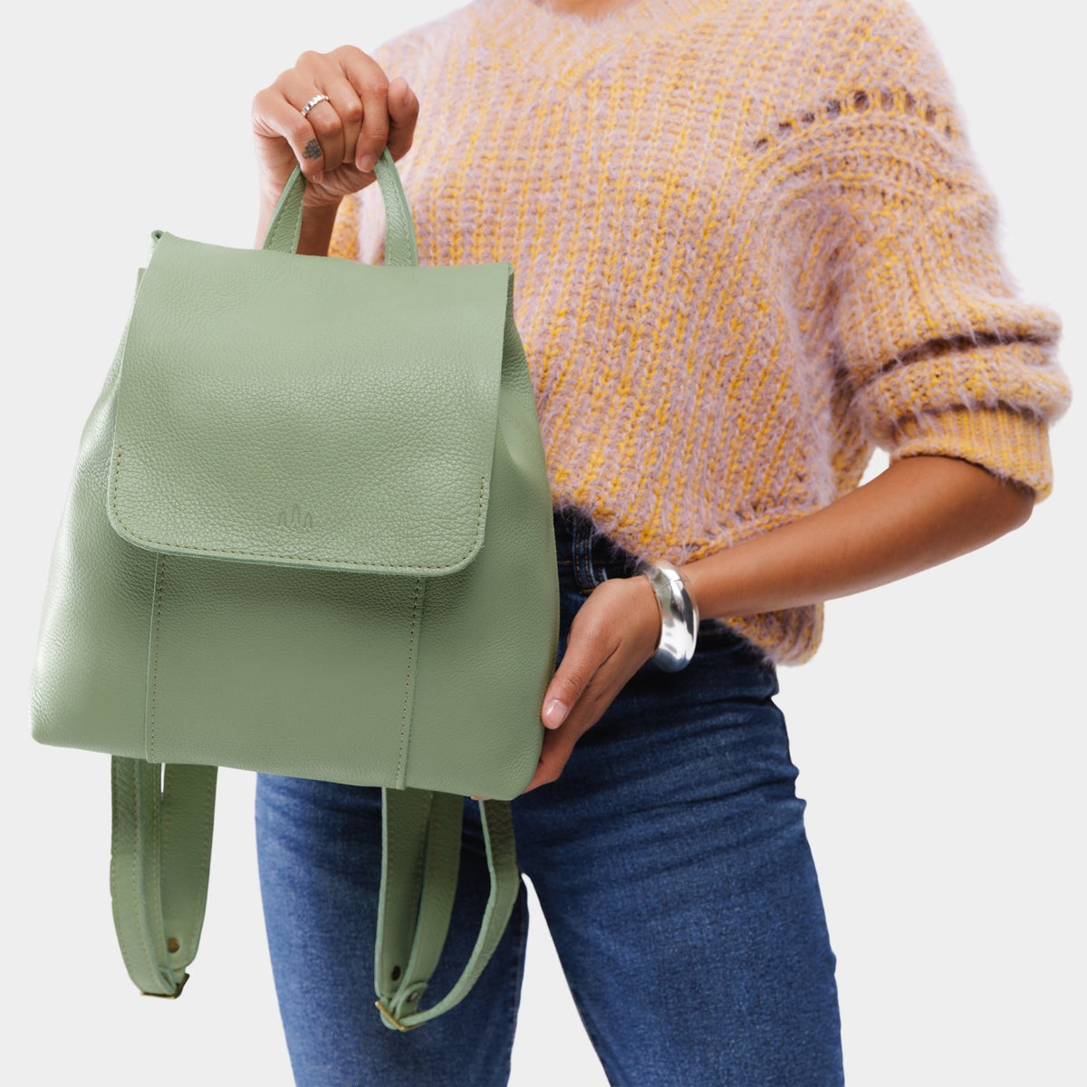 Pistachio | Model wearing a leather backpack on a white background