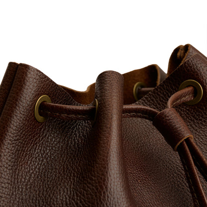 Coldbrew | Close-up of a brown leather drawstring backpack with grommets.