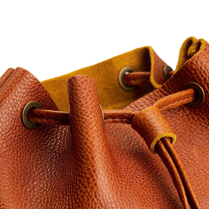 Sienna | Close-up of a leather drawstring backpack with grommets.