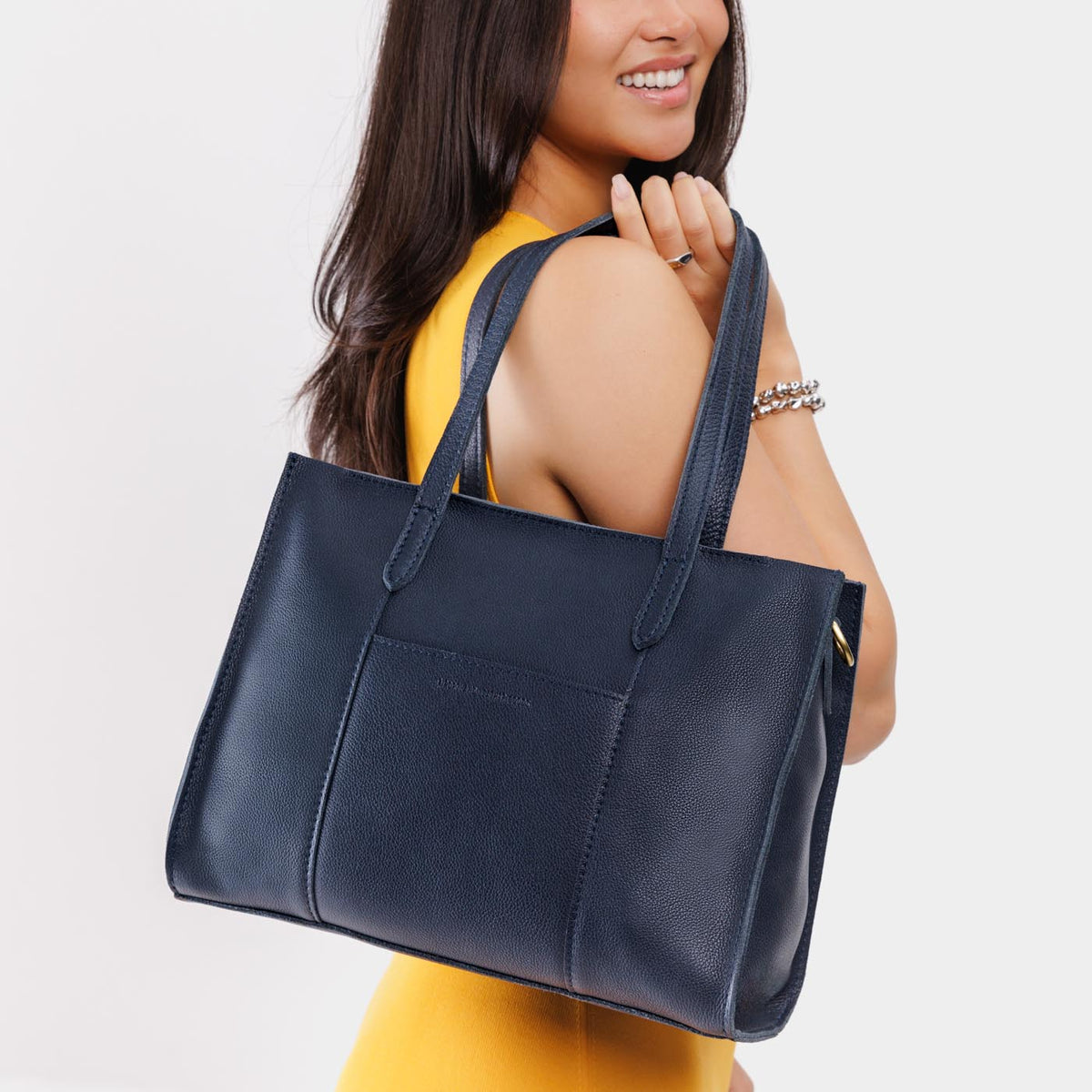 Night Owl*East/West | Model wearing structured wide tote bag with overlapping panels and crossbody strap