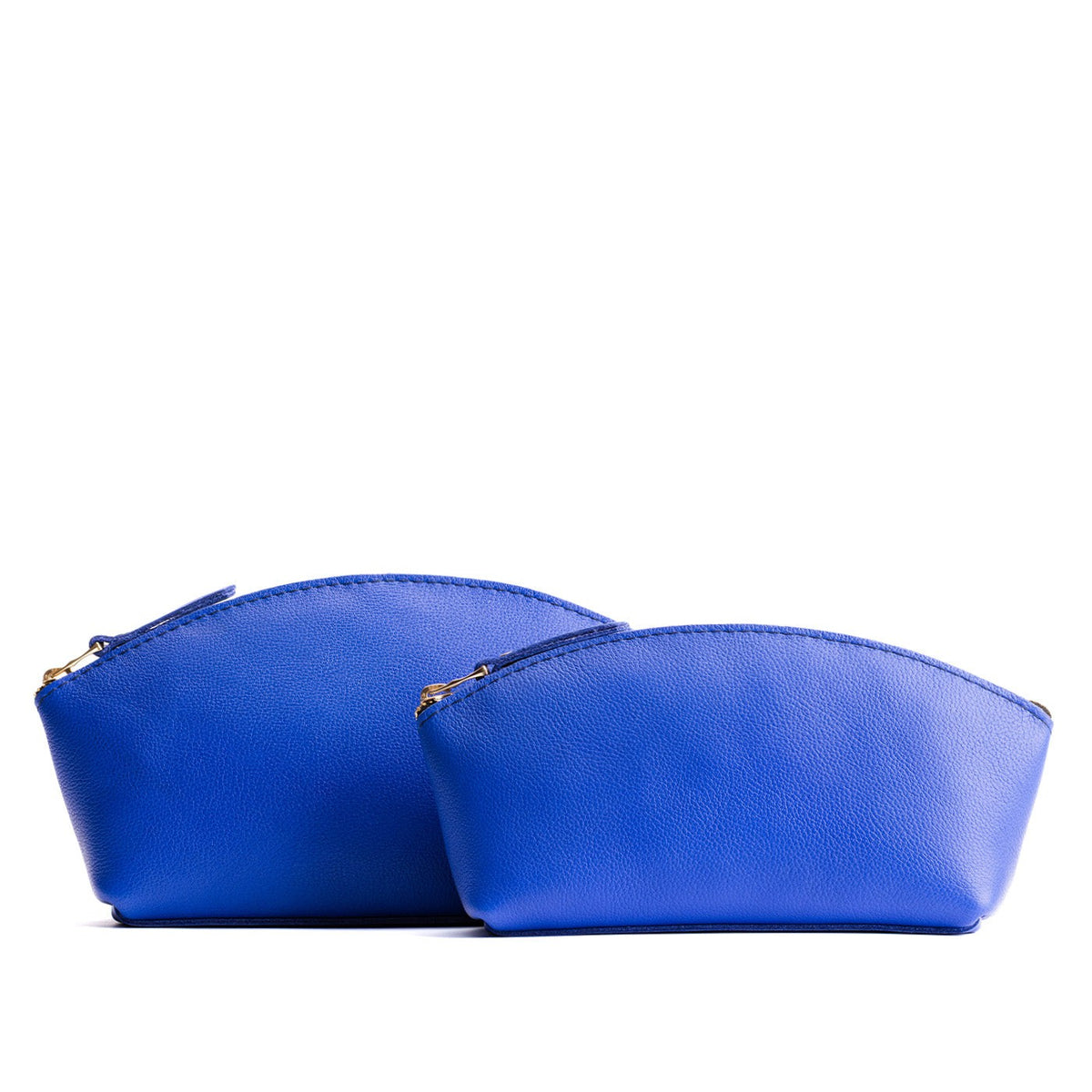 Astro Blue | Size comparison shot of 2 spacious leather makeup bags with curved seams and top zipper