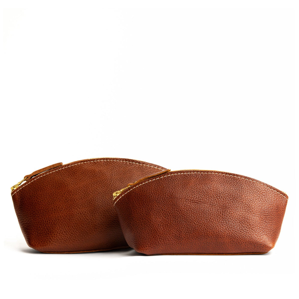 Nutmeg | Size comparison shot of two spacious leather makeup bags with curved seams and top zipper