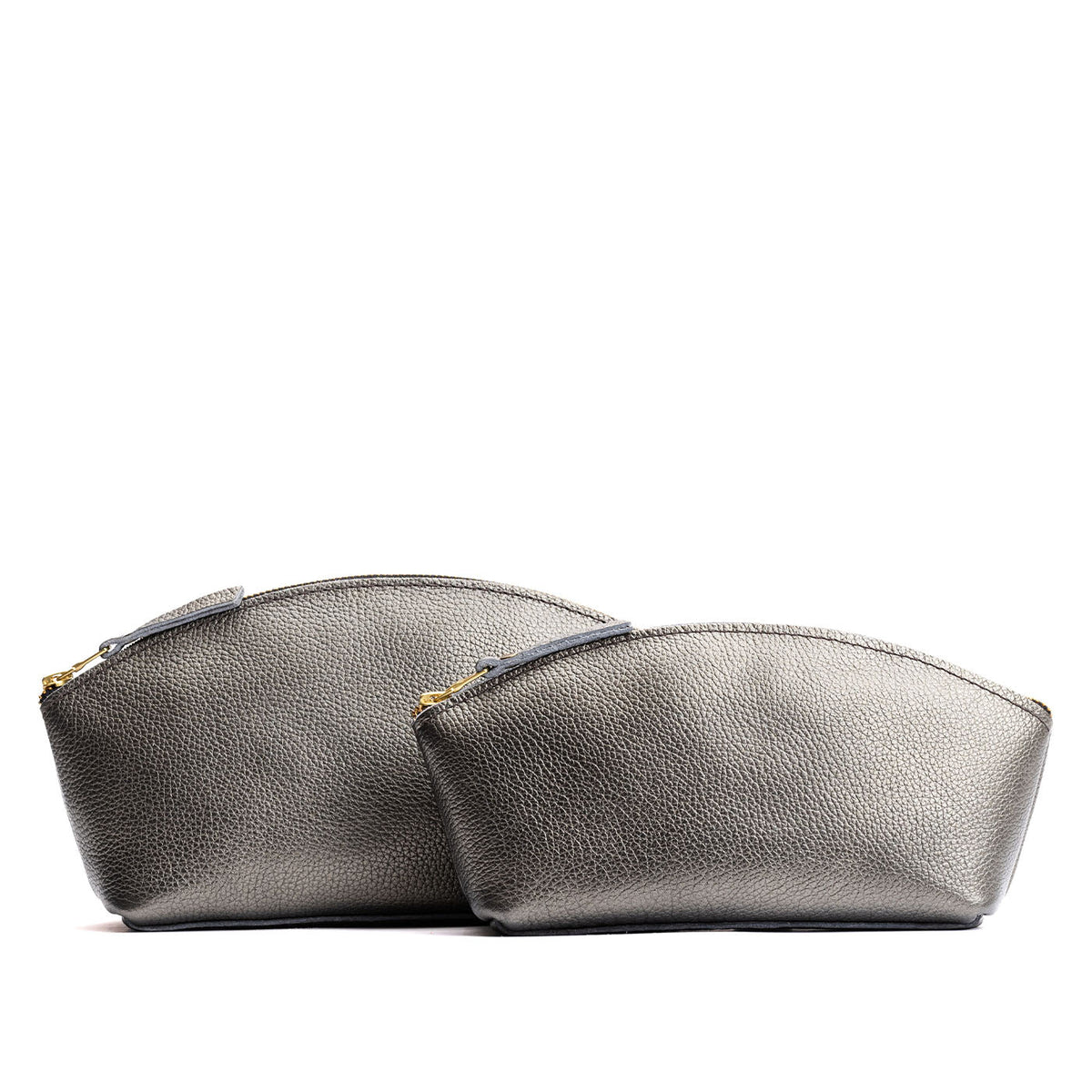 Stardust | Size comparison shot of two spacious leather makeup bags with curved seams and top zipper