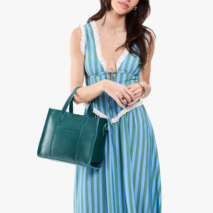 Sea Glass | Model carrying structured mid-size tote bag with overlapping panels and crossbody strap