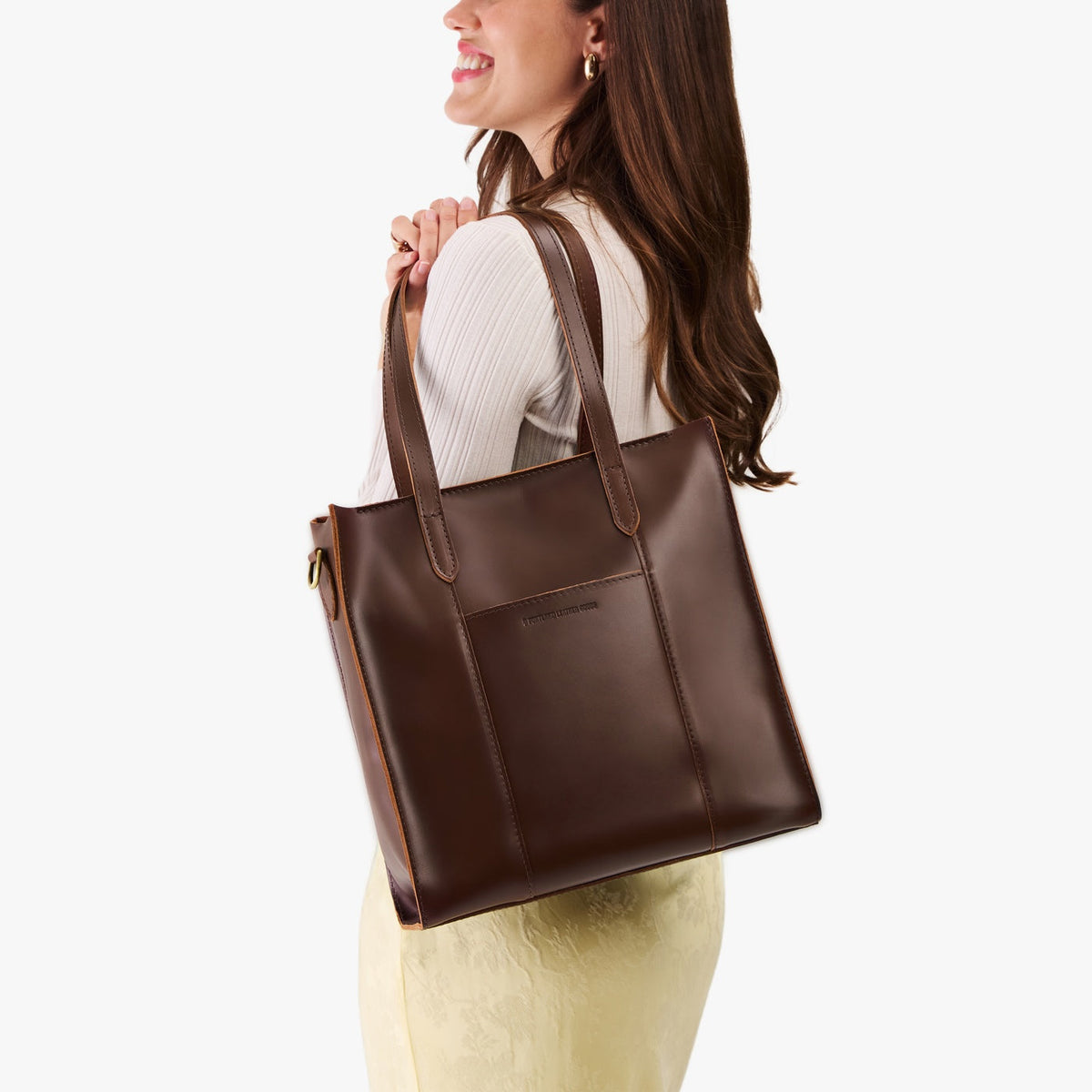 Chocolate Brown*North/South | Model wearing structured large tote bag with overlapping panels and crossbody strap