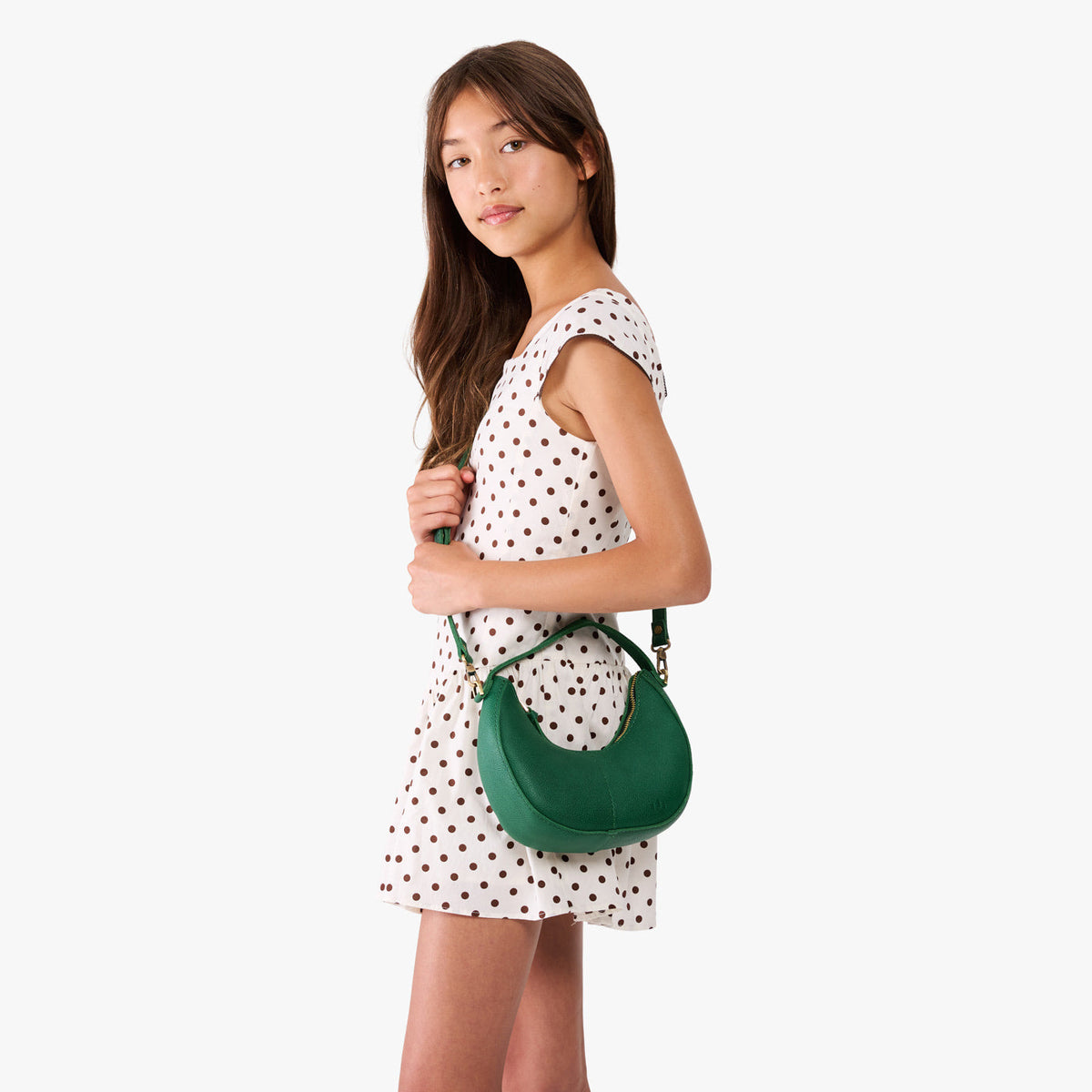 Bacalar | Model with a crescent shaped shoulder bag with zipper closure and gold accents