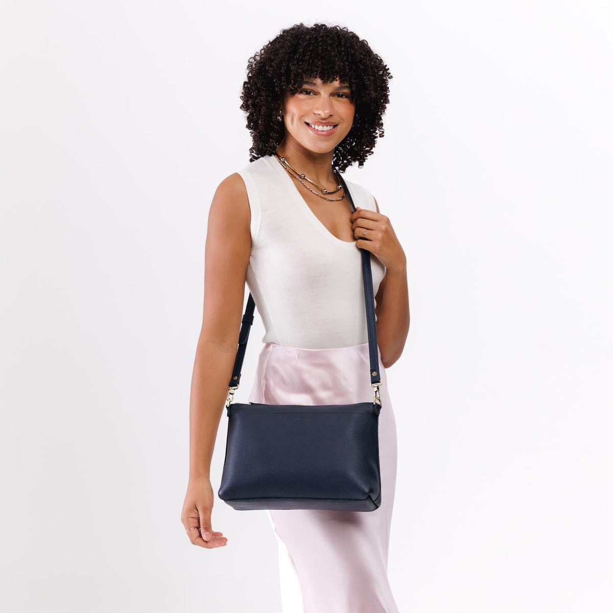 Night Owl*Large | A Model holding a zip top crossbody bag with detachable strap