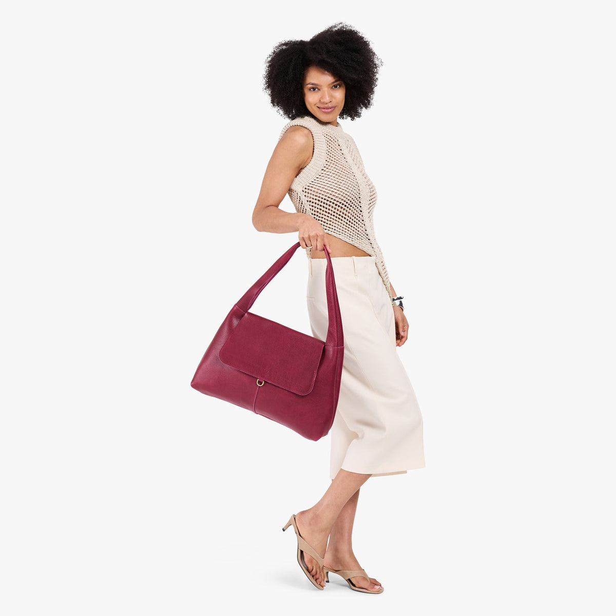 Orchid*Large | A model holding a slouchy triangle shaped shoulder bag with a flap