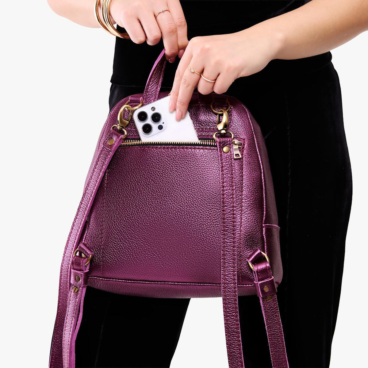 Ultra Violet | Model pulling smartphone out of back zipper pocket of a leather backpack