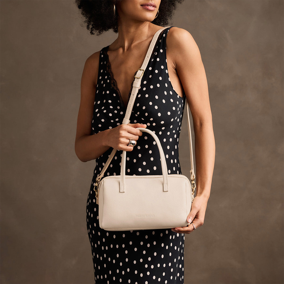 Pebbled Bone*Large | Model holding mini duffle shaped handbag with crossbody strap
