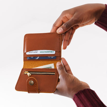 Honey | Model holding small leather bifold wallet with snap open